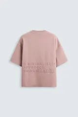 Camiseta color crema de corte recto, cuello redondo y manga corta. Estampado con texto en relieve en el frente.