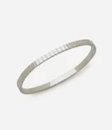 Pulsera tipo brazalete rígido de acero inoxidable, color plateado, compuesta por eslabones cuadrados unidos, creando una textura acanalada y geométrica.