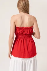 Strappless fruncido color rojo, suelto de la cintura hacia abajo.