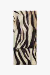 Pañuelo rectangular de modal con estampado de cebra en tonos beige y negro, y terminaciones desflecadas.
