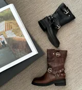 Bota de cuero vacuno color marrón, con suela de goma artesanal, caña ajustable con hebilla y cierre interno YKK.