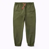 Pantalón jogging color verde oliva confeccionado en nylon reciclado con tecnología DWR (Durable Water Resistance). Cuenta con cintura y puños elásticos, cordón de ajuste naranja, dos bolsillos laterales abiertos y un bolsillo con cierre en la parte superior.