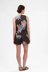 Chaleco gris con estampado de flores y tigre, con cuello en V y cierre con botones.