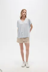 Blusa color beige de lino, holgada y con cuello en V.