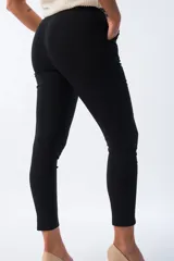 Pantalón negro de corte aline con cintura plisada y lazo estampado animal print.