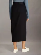 Falda midi de denim color negro, de tiro alto, corte recto y abertura frontal.