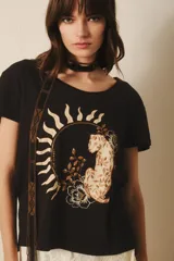 Remera negra de algodón con estampa de un felino dentro de un círculo con rayos de sol.