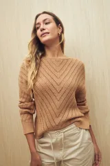 Sweater color tostado, tejido con diseño calado en forma de espiga, escote redondo y mangas largas.