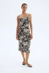 Vestido midi ajustado con breteles finos y escote drapeado. Presenta frunces laterales que generan un efecto drapeado.