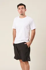 Bermuda deportiva de nylon color verde oliva, de corte suelto, con cintura elástica y cordón de ajuste. Cuenta con detalles de líneas verticales en los costados y bolsillos laterales con cierre.