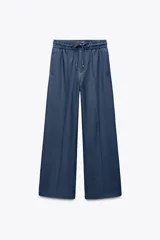 Pantalón azul de tiro alto con cintura elástica ajustable con cordón, corte ancho, bolsillos laterales y traseros.