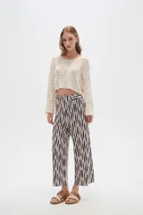 Pantalón recto de poliéster con estampado a rayas verticales en blanco y negro.