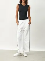 Pantalón blanco de corte ancho con una fina línea negra vertical en los laterales.