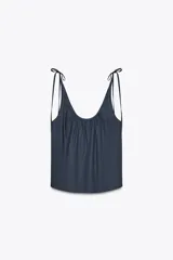 Top azul de popelina con escote redondo, tirantes finos con lazadas y detalle de pliegues.