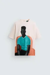Camiseta color crema de corte holgado con cuello redondo y mangas cortas. Estampado frontal con la ilustración de un hombre sentado en un sillón.