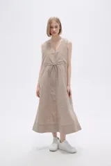 Vestido midi color beige de lino, sin mangas, con escote en V, bolsillos laterales y cordón ajustable en la cintura.