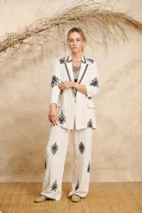Blazer color crema de lino con bordados florales negros en solapa, mangas y ruedo.