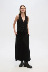 Pantalón ancho de tiro alto, color negro, con bolsillos laterales y confección en tela de lino.