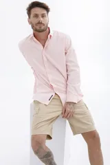 Camisa rosa de manga larga con cuello clásico y cierre frontal con botones. Corte recto.