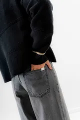 Pantalón jean de tiro medio color negro, corte mom, con bolsillos delanteros y traseros. Largo hasta el tobillo. Confeccionado en algodón 100%.