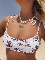 Conjunto de bikini con corpiño estampado floral con tiras finas y bombacha colaless lisa color verde oscuro.