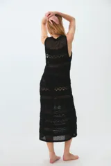 Vestido negro de tejido de punto calado, largo midi, con escote en V y tirantes anchos.