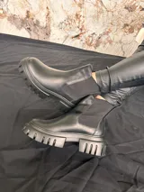 Bota de cuero negra de media caña con plataforma y suela track.