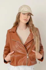 Campera estilo motociclista de cuero color marrón caramelo, con cuello solapa, cierre asimétrico plateado y detalles de broches metálicos.