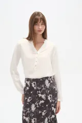 Blusa de viscosa con cuello mao y abertura frontal con botones. Presenta un estampado de rayas verticales finas en tonos azul claro, blanco, marrón y azul oscuro.