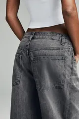 Jeans de tiro medio, estilo balloon baggy, color gris oscuro lavado. Presenta pierna muy ancha y largo completo, con aberturas sutiles en los bajos.