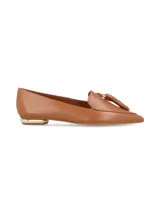 Zapato mocasín color marrón cuero, con punta fina y detalle de borlas. Presenta un pequeño taco cuadrado con aplique dorado.
