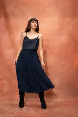 Falda midi plisada de seda color negro, con cintura elástica.