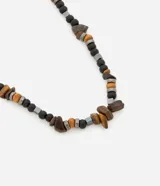 Collar corto con cuentas de piedra color marrón, cuentas de madera color beige, cuentas metálicas color gris y cuentas de madera color negro.
