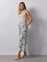 Pantalón crop de lino estampado con hojas en tonos verdes y azules. Tiene pretina trasera elastizada y bolsillos delanteros.