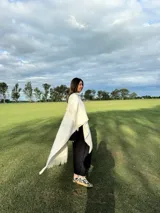 Zapatillas bajas con estampado animal print de vaca en blanco y negro, con cordones marrones y suela color caramelo.