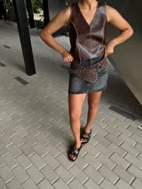 Faja ancha de cuero color borgoña con tachas plateadas y hebilla metálica circular.