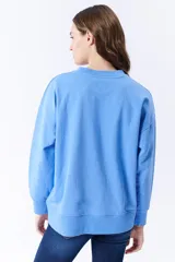 Buzo deportivo celeste de corte holgado, con cuello redondo y mangas largas.