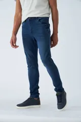 Jean skinny de tiro medio, color azul oscuro, con logo bordado y pasacinto.