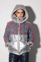 Campera con parte superior de paño de lana color crema y parte inferior impermeable plateada. Forrada con peluche y capucha desmontable.
