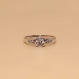 Anillo de plata 925 con una circonia central redonda y tres circonias más pequeñas a cada lado.