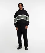 Buzo masculino con capucha, confeccionado en algodón y poliéster. Presenta diseño a rayas y bloques de color, con mangas largas ajustadas.