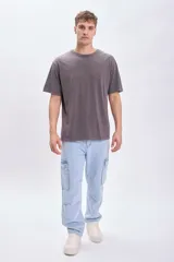 Remera de manga corta gris oscuro con estampa circular en la espalda con un sol en el centro y la frase "Catch the sun, chose the surf".