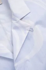 Camisa estilo camper, de fit boxy, confeccionada en popelina con estampa de mármol celeste y blanco. Tiene cuello tipo camp-collar y botones de madera.