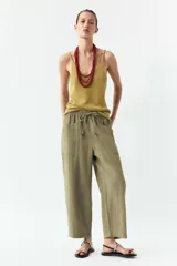 Pantalón color verde oliva de tiro alto, corte ancho y largo 7/8. Tiene cintura elástica ajustable con cordón, bolsillos de plastrón en delantero y espalda.