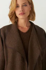 Tapado marrón de largo medio, abierto, con cuello y envivado. Hecho 100% en Uruguay con tela 100% lana fina sin teñir, diseñada exclusivamente por Don Baez.