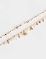 Set de dos collares cortos dorados, uno con cadena de eslabones y dijes de perlas, gotas y concha marina, y otro con mostacillas de colores.