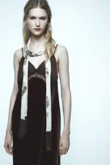 Vestido midi de terciopelo negro con escote pico y tirantes finos ajustables. Detalle de encaje en contraste en el escote.