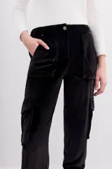 Pantalón babucha verde esmeralda de terciopelo con elástico en la botamanga, bolsillos plaqué en el frente con remaches metálicos y bolsillos cargo en las piernas.