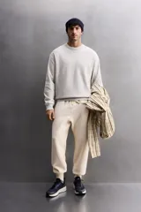 Sudadera de entrenamiento color gris claro, de corte relaxed fit, confeccionada en tejido de algodón con interior de rizo. Tiene cuello redondo, manga larga y acabados en rib.