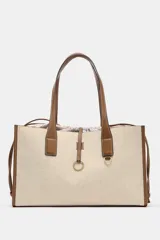 Bolso maxi shopper de hombro color beige con detalles en cuero marrón. Doble asa en contraste de tejido. Incluye bolsa de tela extraíble con cierre fruncido y tira con anilla metálica.